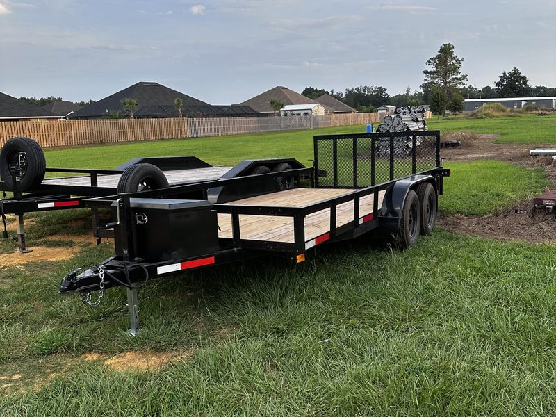 The 16 by 7 utility trailer with a wood deck, side rails, and a fold-down mesh ramp gate